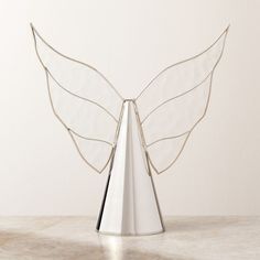 a metal angel sculpture sitting on top of a table