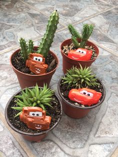 three potted plants with cars made to look like people's faces on them