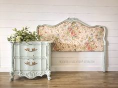 a white bed sitting next to a dresser on top of a hard wood floor