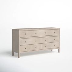 a white dresser with six drawers and two handles on each drawer, in front of a plain background