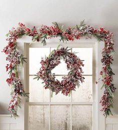 a christmas wreath is hanging on the window sill in front of an open window