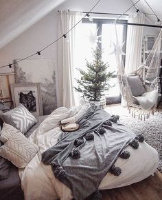 a bedroom with a hammock, bed and christmas tree in the corner on the floor