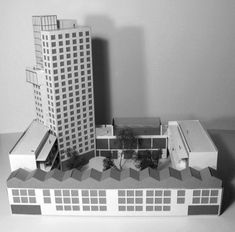 an architectural model of a building with trees in the foreground and buildings on the other side