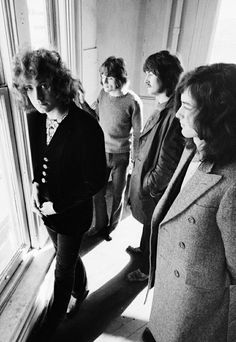 black and white photograph of four women standing in front of a window looking at something