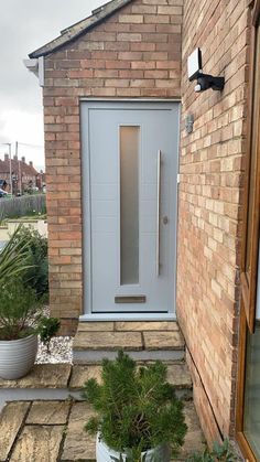 a grey front door and some plants outside