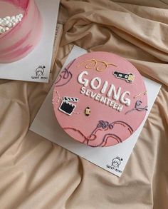 a pink cake sitting on top of a bed next to a card with the words going seventies