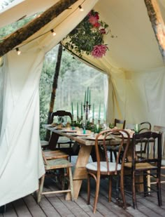 a dining table and chairs under a tent