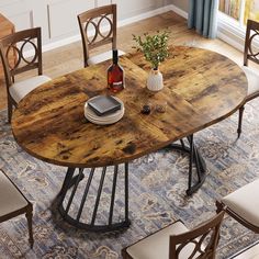 a dining table with chairs around it and a bottle of wine on the table top