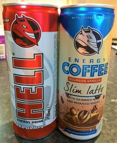 two cans of energy drink sitting on top of a counter