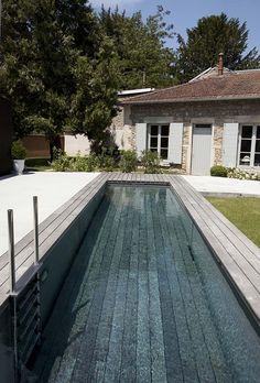 an empty swimming pool in front of a house