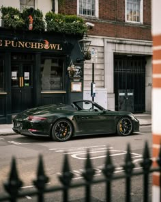 a green sports car parked in front of a restaurant