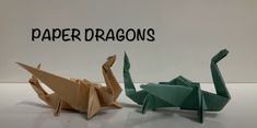 two origami cranes sitting next to each other with the words paper dragon on it