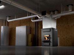 there is a wood burning stove in the middle of an empty room with wooden walls