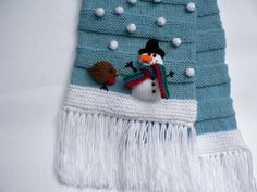 a knitted scarf with a snowman on it and a bird perched on top