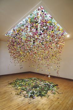 a room filled with lots of multicolored confetti falling from the ceiling