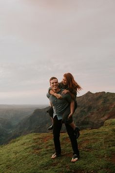 a man holding a woman on top of a hill