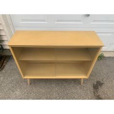 a small wooden shelf sitting in front of a garage door