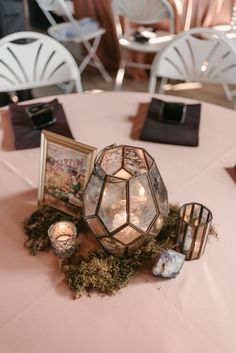 a table topped with pictures and candles on top of a pink cloth covered tablecloth