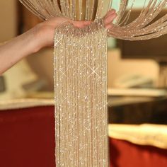 a person is holding some kind of beaded curtain