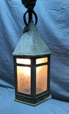 an old fashioned lantern is lit up against a blue background