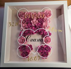 a white box with pink roses in the shape of a heart and name on it