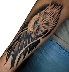 an eagle tattoo on the arm is shown in black and grey colors, with blue eyes