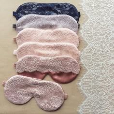 three pairs of eye masks on top of a lace doily next to an empty piece of cloth