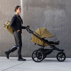 a woman pushing a stroller with a baby in it