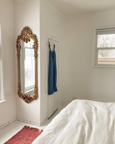 a bedroom with a bed, dresser and mirror on the wall next to a window