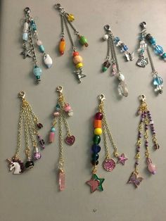 several different types of necklaces hanging on a refrigerator freezer with beads and charms attached to them