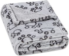 a blanket with black and white dog paw prints on the front, rolled up in half