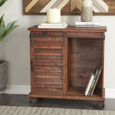 a wooden cabinet with two books and a candle on top