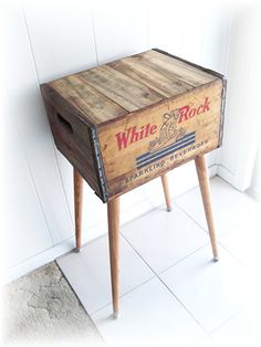 an old wooden crate sitting on top of a white tiled floor