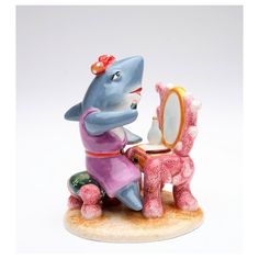 a figurine of a girl brushing her teeth in front of a small mirror