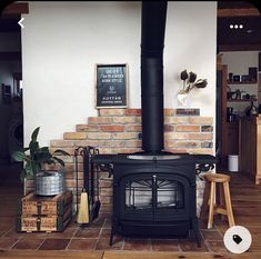 a black stove sitting inside of a kitchen next to a wooden table and stools