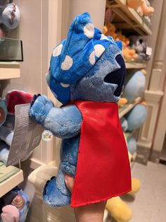 a blue stuffed animal wearing a red cape