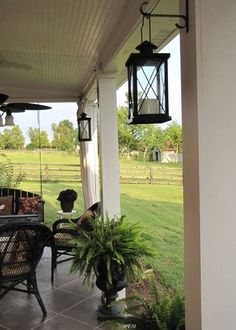 the porch is covered with plants and hanging lantern lights on it's side wall