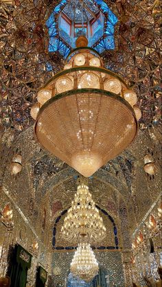 an ornate chandelier hangs from the ceiling in a large room with many lights