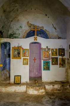 an old church with paintings on the walls and a purple door in front of it