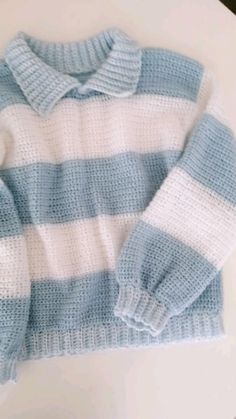 a blue and white sweater sitting on top of a table