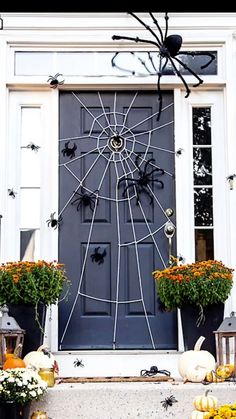 a front door decorated for halloween with pumpkins and gourds