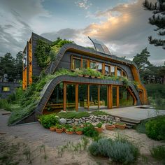 an unusual house with green plants growing on the roof and stairs leading up to it