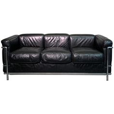 a black leather couch sitting on top of a white floor