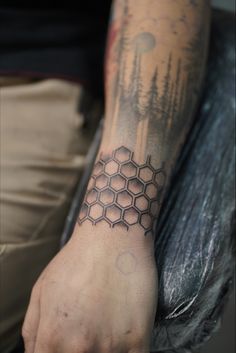 a man's arm with a tattoo on it that has an image of a honeycomb