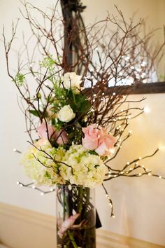 a vase filled with lots of flowers on top of a table