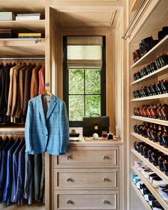 a closet filled with lots of men's shoes and ties on shelves next to a window