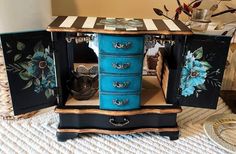 an old dresser has been painted with flowers and stripes on it's sides, along with other decorative items