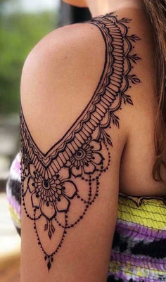 the back of a woman's shoulder with an intricate design on it