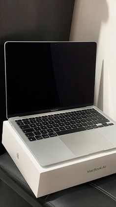 an open laptop computer sitting on top of a white box