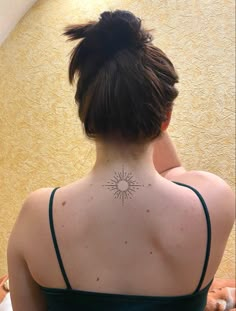 a woman with a sun tattoo on her back